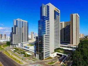 a group of tall buildings in a city at APT Perfeito, duas suítes no shopping Dfplaza in Brasilia