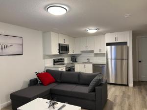 a living room with a couch and a kitchen at Cozy New Suite in NW Calgary in Calgary