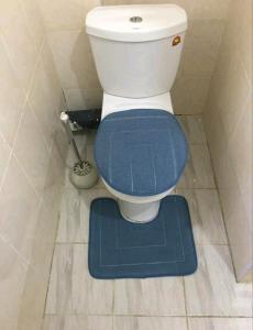 a toilet with a blue seat in a bathroom at Ajay's residence in Hanya