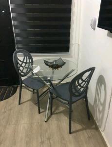 a glass table with two chairs and a candle on it at Ajay's residence in Hanya