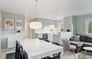 a kitchen and living room with a white table and chairs at Lovely Home In Frvang With Kitchen in Fårvang