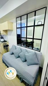 a bed in a room with a large window at 1BR Condo Unit at Celandine Condominium Near Ayala Cloverleaf Mall in Manila