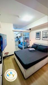 um quarto com uma cama grande e um sofá em 1BR Condo Unit at Celandine Condominium Near Ayala Cloverleaf Mall em Manilla
