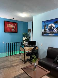 a living room with a desk and a couch at Estancia María Bonita Morelia in Morelia