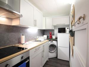 - une cuisine avec des placards blancs et un lave-linge/sèche-linge dans l'établissement Appartement Mont-Dore, 2 pièces, 6 personnes - FR-1-415-149, à Le Mont-Dore