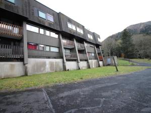 un parking vide à côté d'un bâtiment dans l'établissement Appartement Mont-Dore, 2 pièces, 6 personnes - FR-1-415-149, à Le Mont-Dore