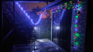 une maison avec des lumières de Noël sur son côté dans l'établissement Río Celeste Nature View, à Upala