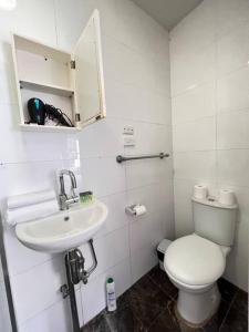 Cozy1 Bedroom Unit Near Maroubra Beach في سيدني: حمام ابيض مع مرحاض ومغسلة