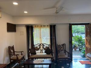 a living room with two chairs and a window at O Abrigo in Panaji