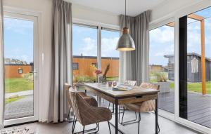jadalnia ze stołem i krzesłami oraz dużymi oknami w obiekcie 2 Bedroom Cozy Home In Ssel w mieście Süsel