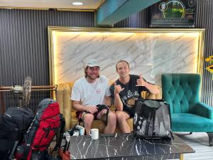 twee mannen op een bank voor een muur bij SS Grey Hotel in Kuala Lumpur