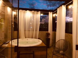 a bathroom with a bath tub and a window at Uai House com jacuzzi (Espaço romântico) in Poços de Caldas