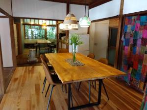 a dining room with a wooden table with a vase on it at 朝食付き唐津里山の宿&ヨガ兎と亀 in Karatsu