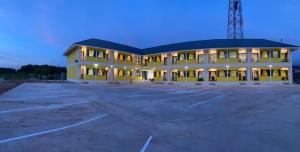 a large yellow building with a parking lot at แอ่ว-ดีLD Hotel&Residences in Ngao