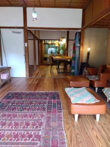 a living room with a couch and a rug at 朝食付き唐津里山の宿&ヨガ兎と亀 in Karatsu