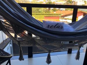 a hammock on a balcony with the word relax at Uai House com jacuzzi (Espaço romântico) in Poços de Caldas