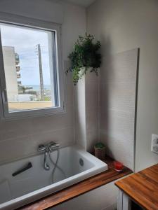 a bath tub in a bathroom with a window at Maison Vue Mer in Pornichet