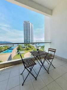 two chairs and a table on a balcony with a view at Southbay Seaview Condo A11 #Queensbay #SPICE in Bayan Lepas