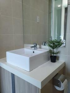a white bathroom sink with a potted plant on it at Southbay Seaview Condo A11 #Queensbay #SPICE in Bayan Lepas