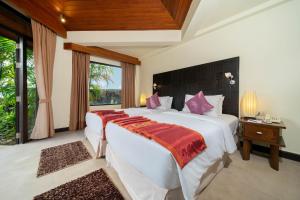 sypialnia z 2 łóżkami i oknem w obiekcie Indochine Resort and Villas - SHA Extra Plus w Patong Beach