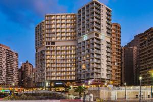 a tall building in a city with tall buildings at Sheraton Montazah Hotel in Alexandria