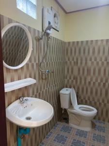 a bathroom with a sink and a toilet and a mirror at Khamphan Guesthouse in Nongkhiaw