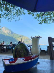 a water melon and a vase sitting on a table at Conforto na Praia do Pontal in Rio de Janeiro
