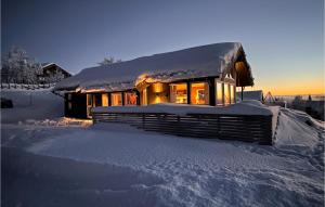 uma casa coberta de neve com as luzes acesas em Awesome Home In Etnedal With House A Mountain View em Etnedal