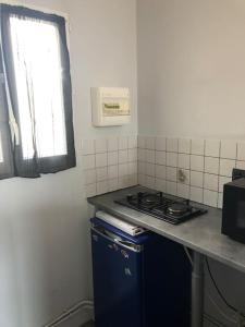 a small kitchen with a stove and a window at Jolie petite maison cosy in Orly