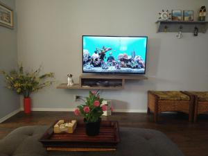 a living room with a flat screen tv on a wall at Charming 1Bedroom Vacation Condo in Oceanside