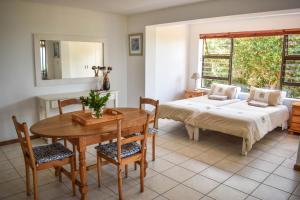 - une chambre avec un lit, une table, une table et des chaises dans l'établissement Sea Gem with a stunning view, à Boggomsbaai