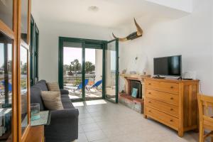 a living room with a couch and a tv at Kelly's Beach House 2 in Gennadi