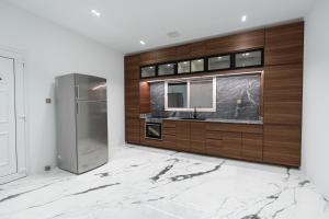 uma cozinha com um lavatório e um frigorífico em La Maison Resort em Doha