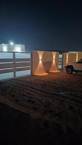 a car parked next to a fence at night at Discovery Camp Bidiya in Badīyah