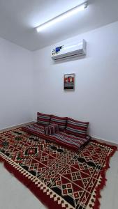 a bedroom with a bed with a rug on the floor at Discovery Camp Bidiya in Badīyah