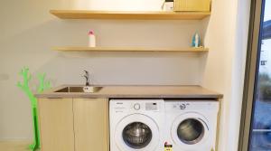 a laundry room with a washing machine and a sink at Two Fantails - Lake Views in Lake Tekapo