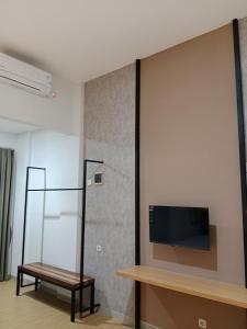 a living room with a tv on a wall at Hotel Andita Syariah in Surabaya
