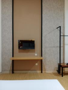 a room with a tv on a wall at Hotel Andita Syariah in Surabaya