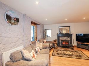 uma sala de estar com dois sofás e uma lareira em Jubilee Cottage em Uig