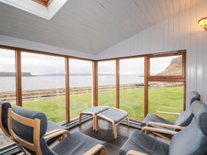 a room with chairs and a view of the ocean at Jubilee Cottage in Uig