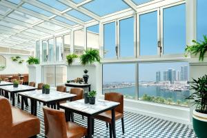 a restaurant with tables and chairs and large windows at The Westin Dubai Mina Seyahi Beach Resort and Waterpark in Dubai