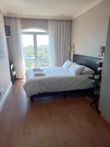 a bedroom with a large bed with a window at Cape Royale Luxury Suite in Cape Town