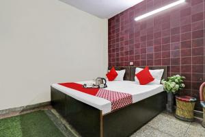 a room with a bed with red pillows at OYO Hotel Lion in New Delhi