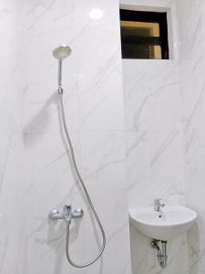 baño con cabezal de ducha y lavamanos en Hotel Andita Syariah en Surabaya