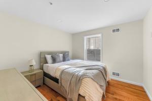 a white bedroom with a bed and a window at Cozy 3BR Newark Apt with Easy Access to NYC and Seton Hall in Newark