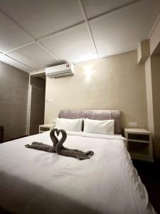 una gran cama blanca con una serpiente puesta en ella en Madras Inn 58-1 Private Bathroom en George Town