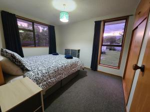 a bedroom with a bed with a black and white comforter at Rockhampton in Kurow