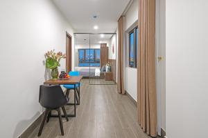 a hallway with a table and chairs and a bedroom at TIDITEL Hotel and Apartment in Da Nang
