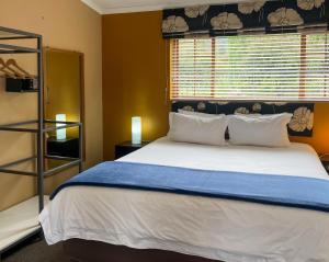 a bedroom with a large bed and a window at The Clarens Country House in Clarens