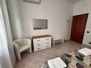 um quarto com uma cadeira, uma cómoda e um espelho em Tia Tourist Apartment Rome em Roma